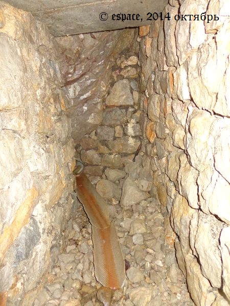 тупик длинной узкой подземной галереи: выход воды из под камня