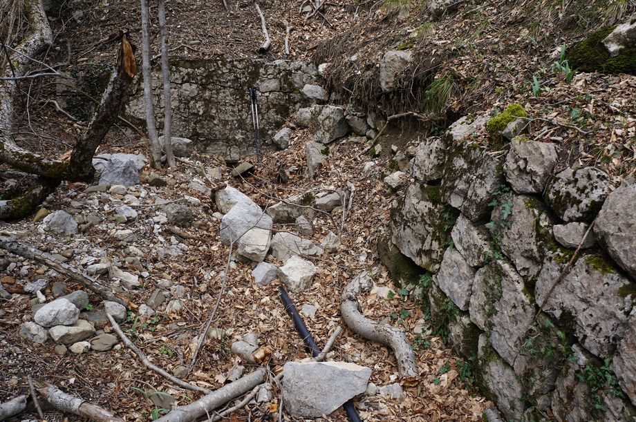 каптаж родника Алия в выемке склона, подпёртый каменными стенами